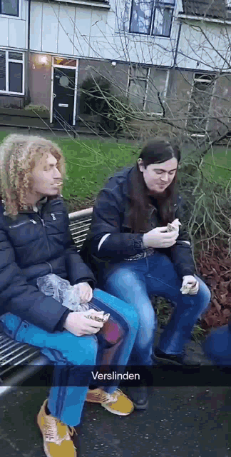 two people are sitting on a bench with the word verslinden on the bottom right