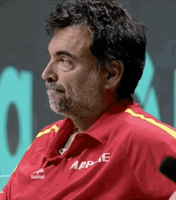 a man with a beard wears a red shirt that says appe on it