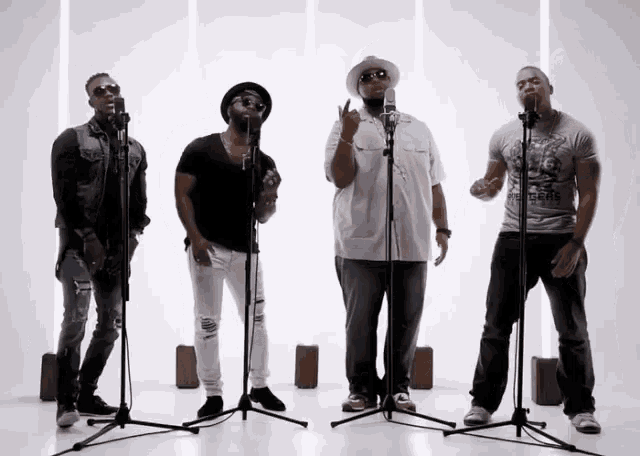 a group of men singing into microphones with one wearing a t-shirt that says california