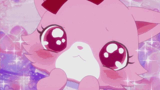 a pink cat with a red bow on its head looks surprised