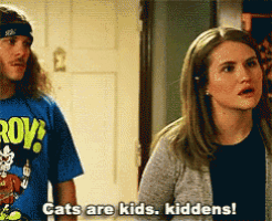 a man and a woman are standing next to each other and the woman is saying cats are kids kiddens