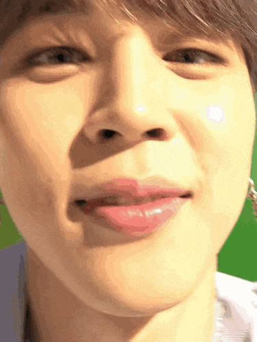a close up of a man 's face with a green background .
