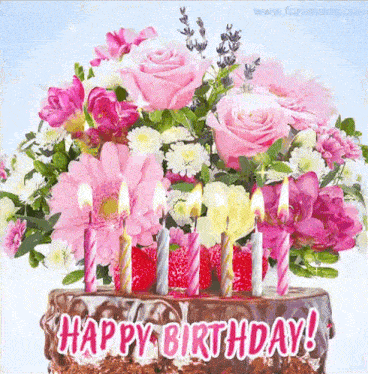 a birthday cake with pink candles and a bouquet of pink and white flowers