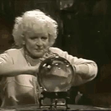 a woman is sitting at a table holding a glass ball .