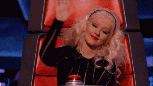 a woman with blonde hair is sitting in a red chair