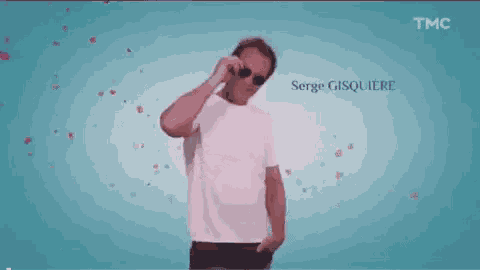 a man in a white shirt is standing in front of a blue background with hearts flying around him .
