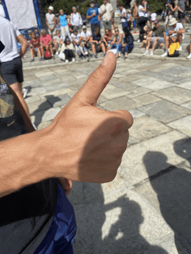 a person is giving a thumbs up in front of a crowd