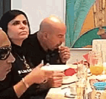 a group of people are sitting around a table eating food .
