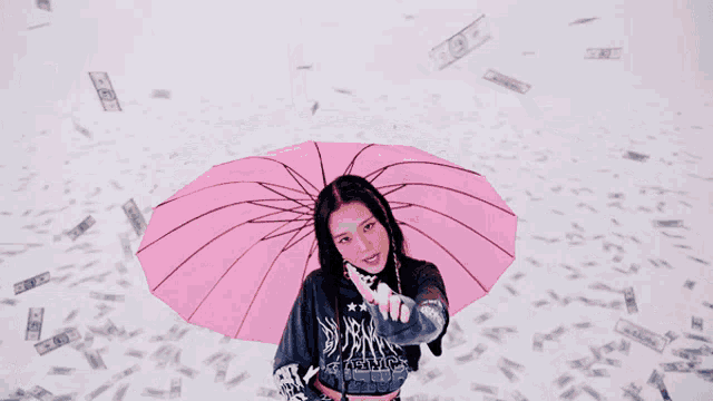 a woman is holding a pink umbrella in front of a bunch of money