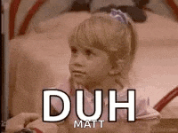 a little girl is sitting on a bed with the words `` duh matt '' written on the screen .