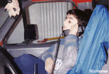 a boy in a car talking on a cell phone with pixverse written on the bottom right