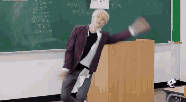a man in a suit is standing in front of a podium in a classroom .