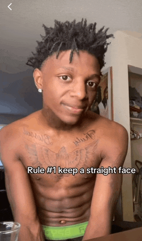 a shirtless man has a tattoo on his chest that says " what "
