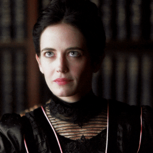 a woman in a black dress is looking down with a bookshelf in the background