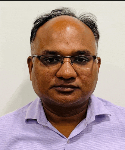 a bald man wearing glasses and a purple shirt looks at the camera