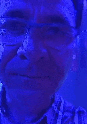 a man in a plaid shirt is standing in front of a blue background