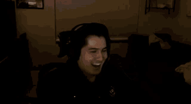 a man wearing headphones is sitting in a dark room .