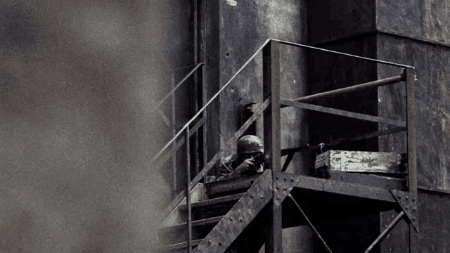 a man sitting on a set of stairs with a gun