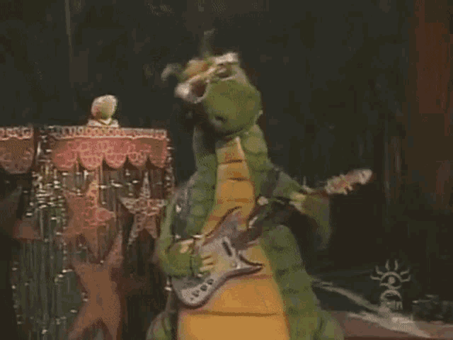 a dinosaur is playing a guitar on a stage .