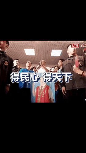 a group of people are standing in a room with chinese writing on the screen