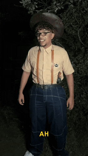 a man wearing a cowboy hat and suspenders is standing in the dark with the words fils de written on the bottom