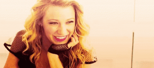 a woman is smiling with her hand on her chin and wearing a fishnet glove .