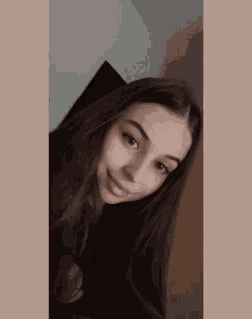 a young woman with long dark hair is smiling for the camera