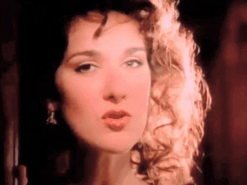 a close up of a woman 's face with curly hair making a funny face .