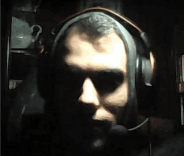 a man wearing headphones and a microphone has a tattoo on his head