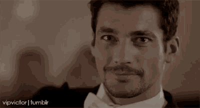 a close up of a man with a mustache wearing a tuxedo and a white shirt .