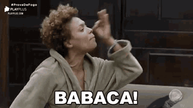a woman in a bathrobe is sitting on a couch making a funny face .