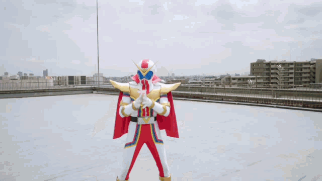 a man in a red white and gold superhero costume holds a cup
