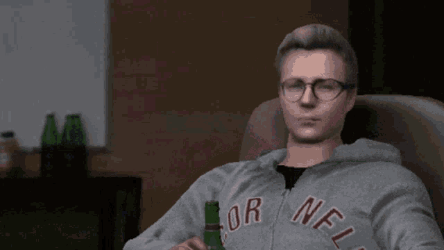 a man wearing a grey nfl sweatshirt sits in a chair holding a beer