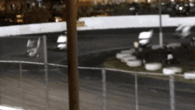 a blurred image of a race track with a fence