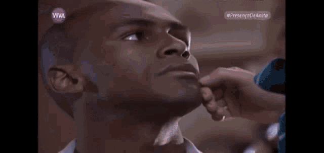 a woman is touching a man 's face and the word viva is on the corner of the screen