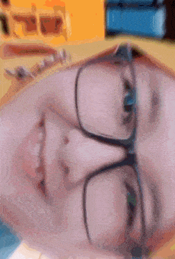 a close up of a person wearing glasses with a yellow background