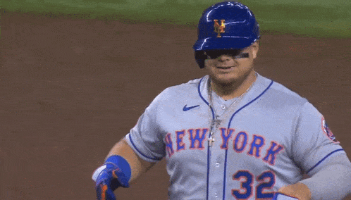 a new york mets baseball player adjusts his glove on the field