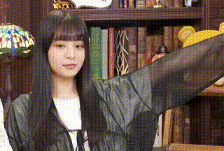 a woman is standing in front of a bookshelf with her arms outstretched and a lamp .