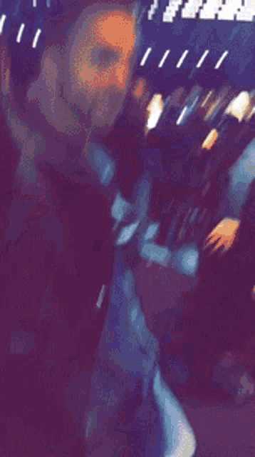 a blurry photo of a crowd at a concert with a person holding a microphone