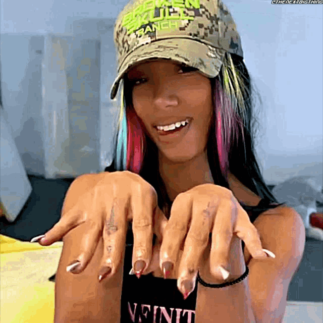 a woman wearing a hat with the word ranch on it shows her nails