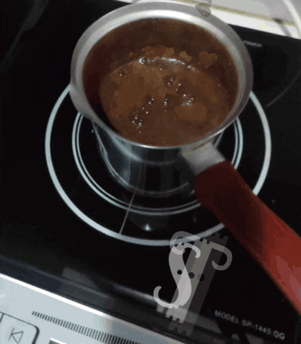 a pot of chocolate is cooking on a model sp-1445 gg stove top