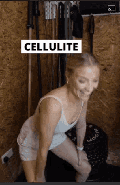 a woman is squatting down with the word cellulite behind her