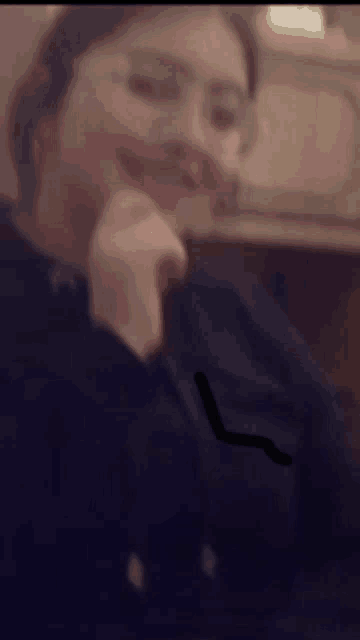 a blurry picture of a woman with glasses and a black shirt