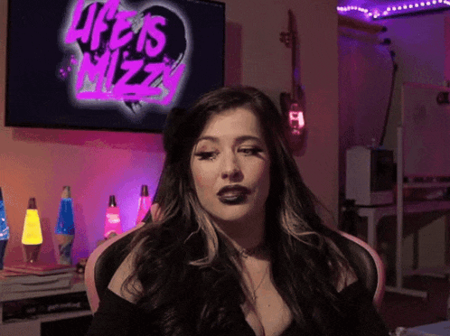 a woman sitting in front of a life is mizzy tv
