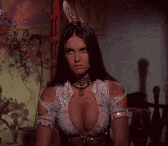 a woman with a very plunging neckline is wearing a purple top