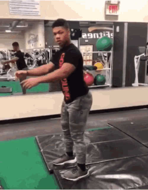 a man in a gym wearing a black shirt that says conditioning