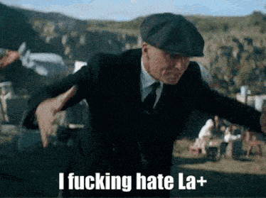 a man in a suit and hat is saying i fucking hate la+