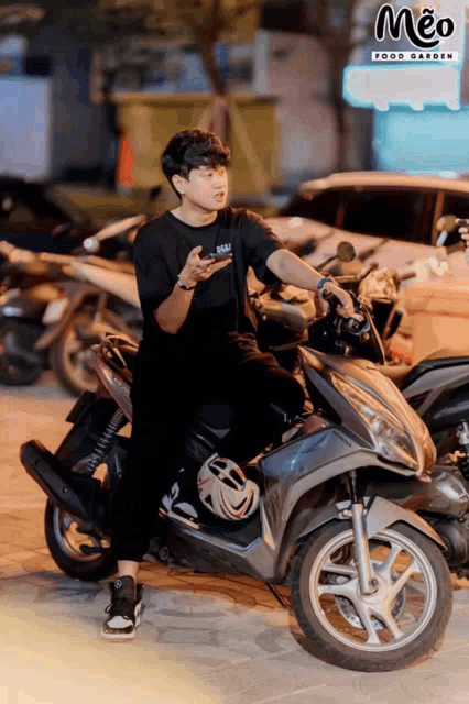 a man is sitting on a scooter in front of a meo food garden sign