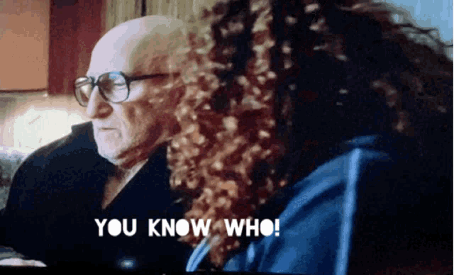 a man with glasses is talking to a woman with curly hair who is saying " you know who "
