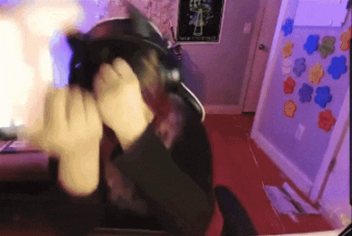 a person covering their face with their hands in front of a computer